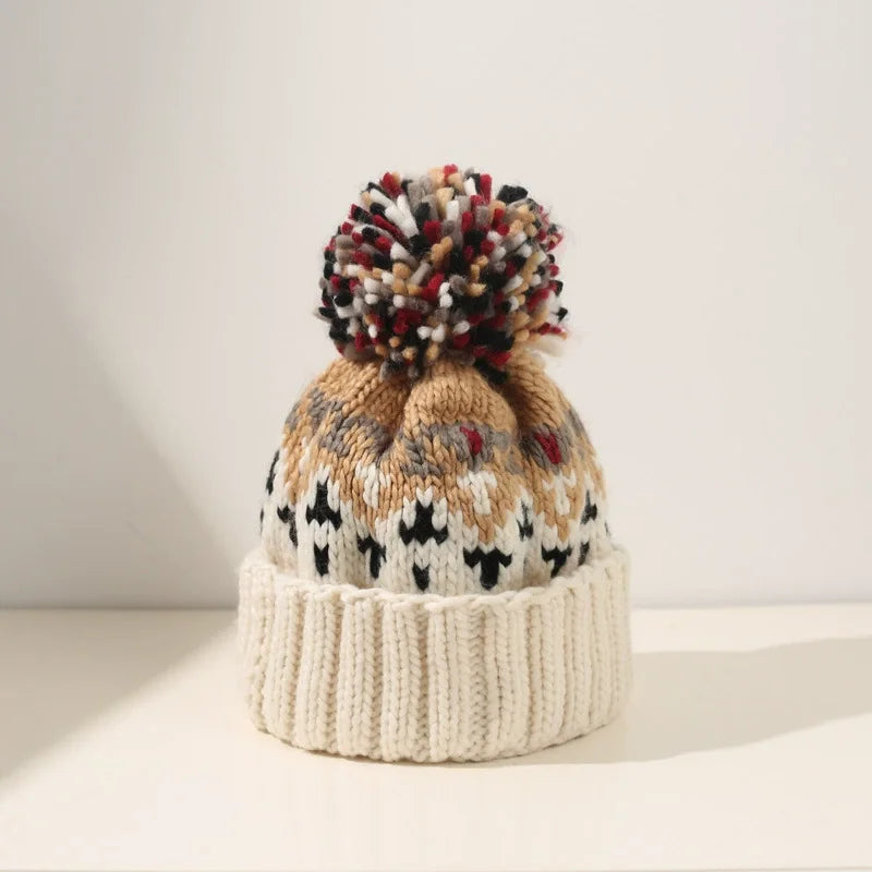 Soft, cozy women's knit beanie hat featuring delicate snowflakes and a fluffy pompom, warm winter accessory.