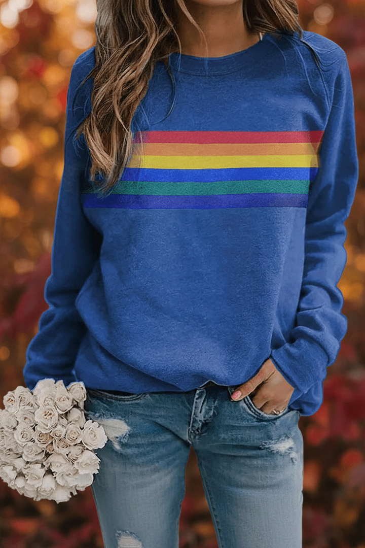 Close-up of a women's cozy rainbow striped pullover sweatshirt, showing soft fabric texture.