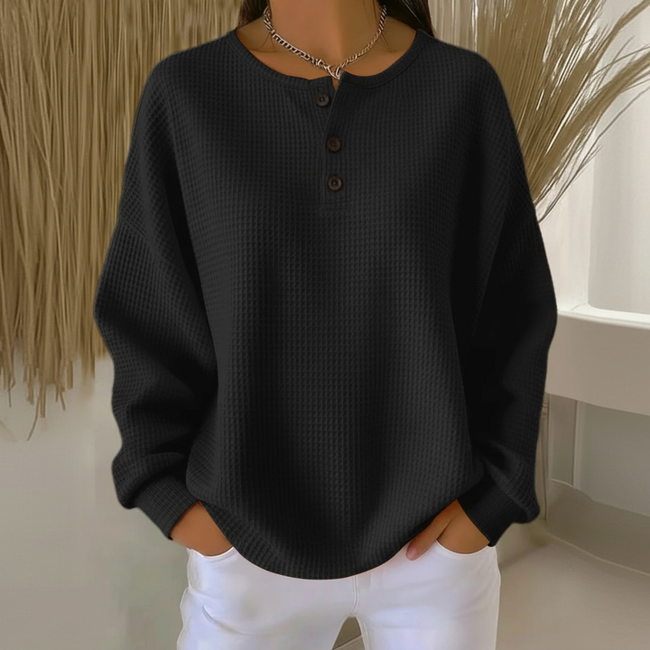 Woman wearing a cozy beige waffle knit sweater, showcasing its relaxed fit and soft texture for fall fashion.