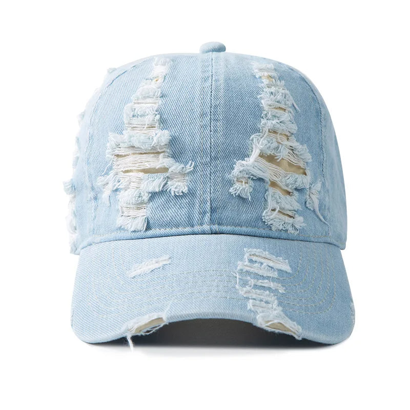 Trendy women's denim cap with distressed details, offering a cool, casual, and untamed streetwear vibe.