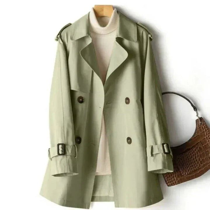 Elegant women's trench coat featuring double-breasted design, belted waist, & adjustable cuffs. Stylish outerwear.