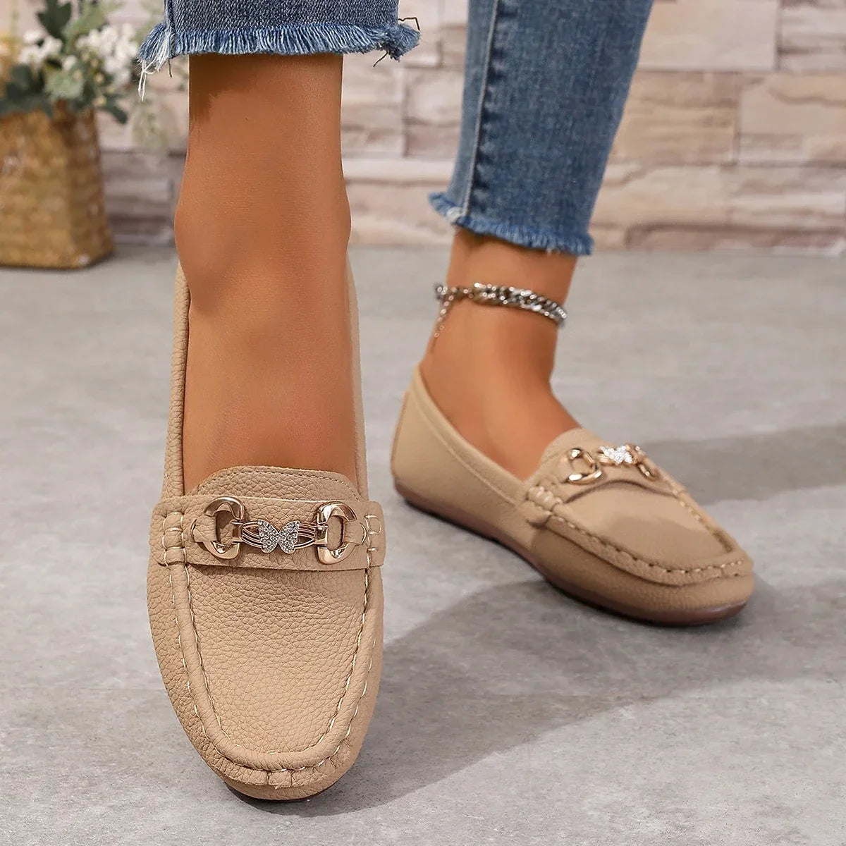 Side profile of elegant women's slip-on loafers, crystal chain visible.