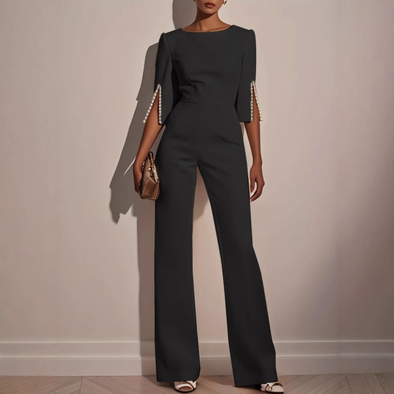 Tailored women's elegant jumpsuit, flattering fit with statement pearl cuffs, ideal for formal occasions.