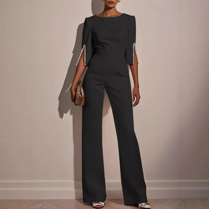 Tailored women's elegant jumpsuit, flattering fit with statement pearl cuffs, ideal for formal occasions.