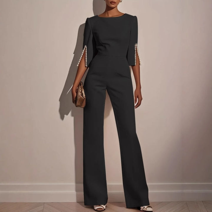 Tailored women's elegant jumpsuit, flattering fit with statement pearl cuffs, ideal for formal occasions.