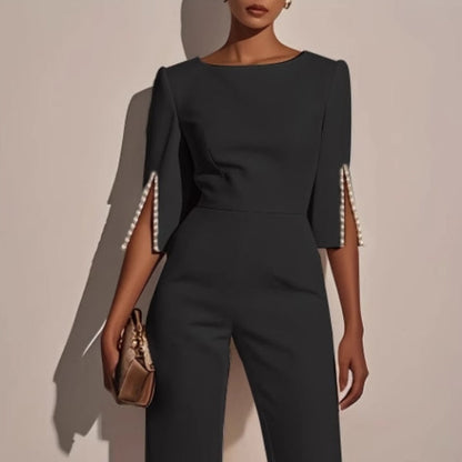 Sophisticated women's tailored jumpsuit with elegant pearl cuffs, perfect for formal evening wear.