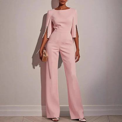 Modern women's elegant tailored jumpsuit with pearl cuffs, a chic and formal option for any special evening.