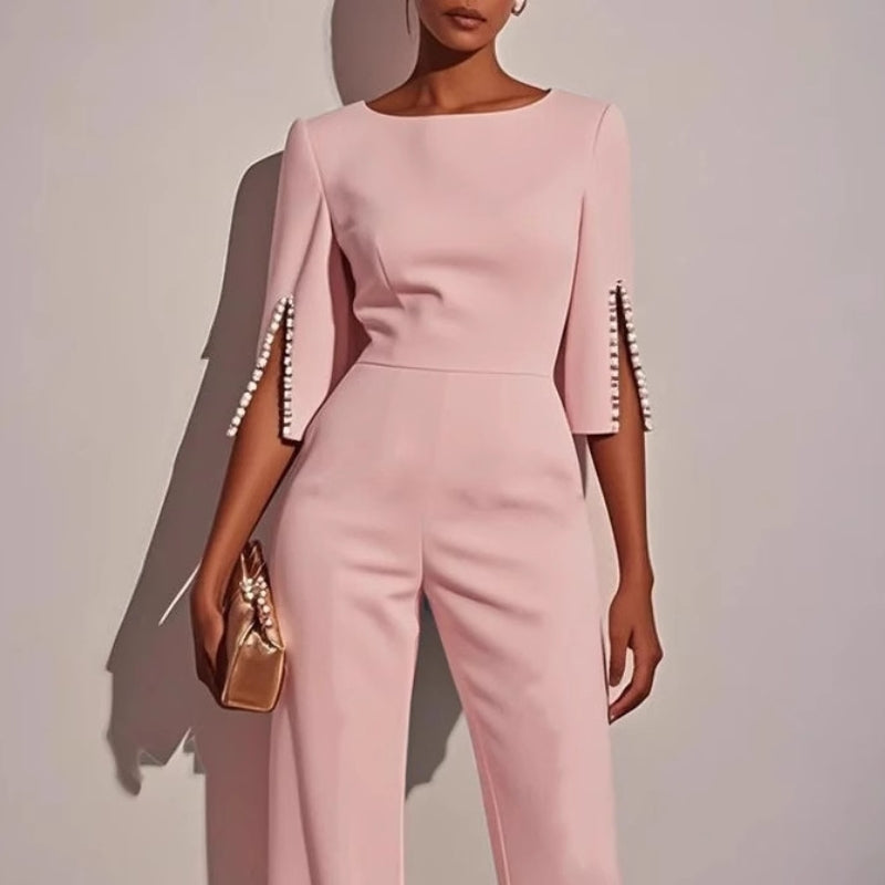 Elegant women's tailored jumpsuit, full length view, showcasing sophisticated design and pearl cuff detail.