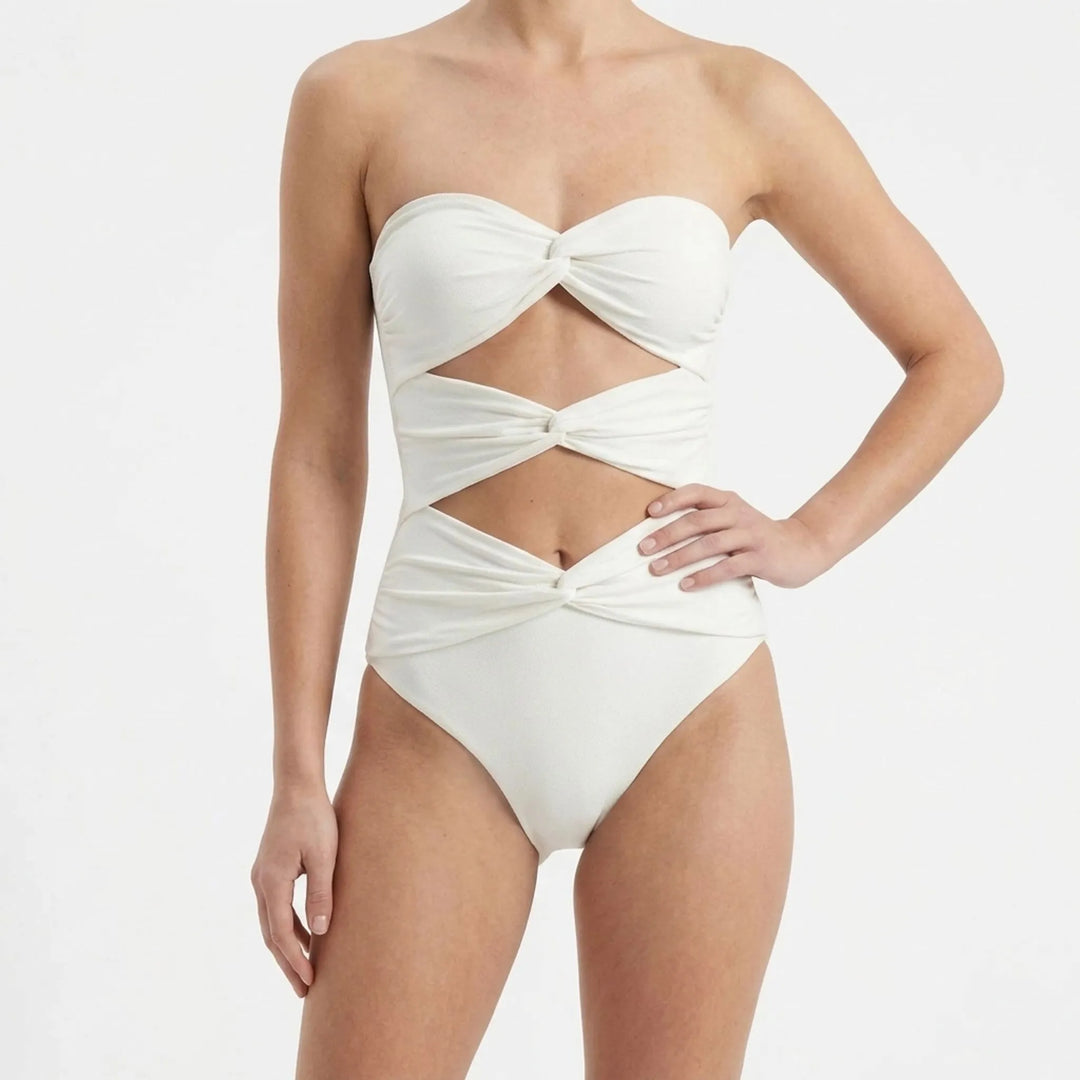 Women's cutout bikini top with a flowing skirt, stylish resort wear set for the beach.
