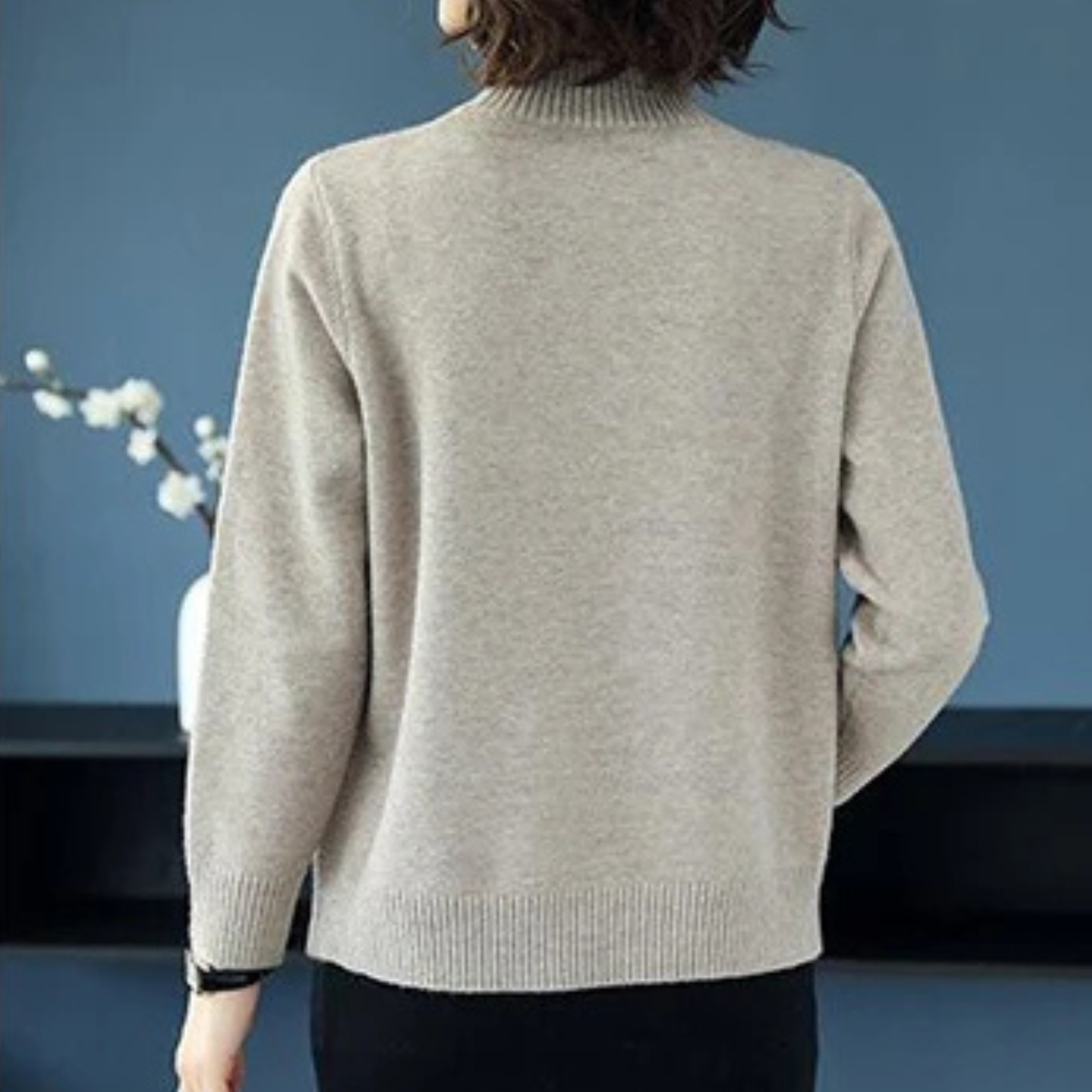 Back view of a warm women's diamond-knit turtleneck sweater, showcasing the quality diamond knit design.