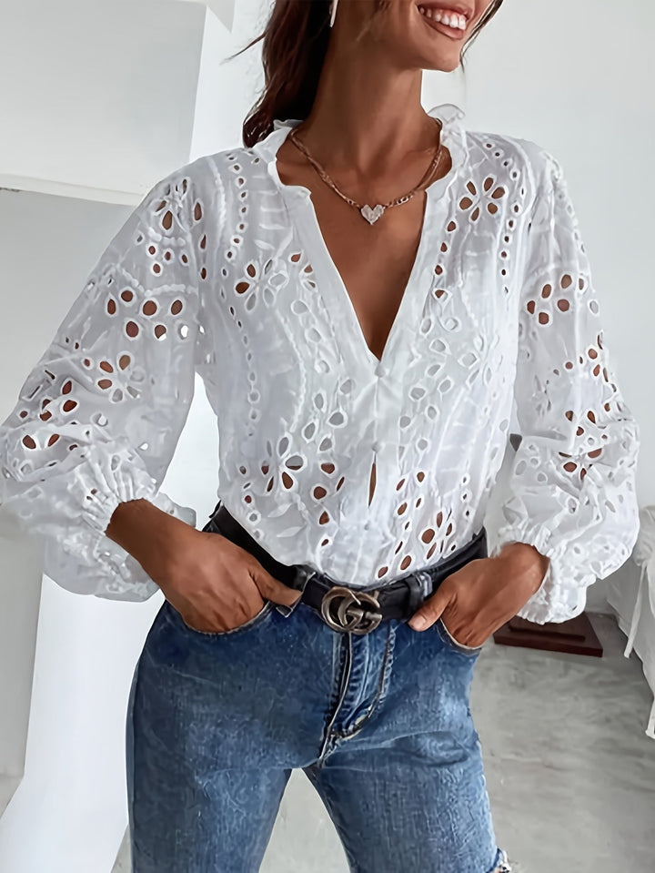 Close-up of women's floral long-sleeve blouse, showing intricate embroidery & delicate button details.