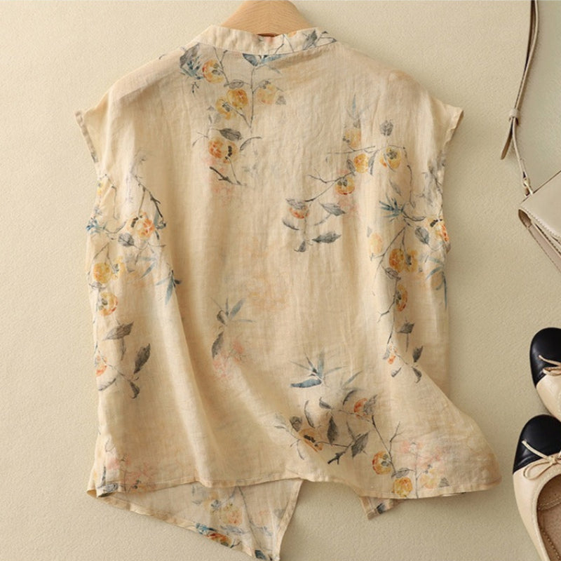 Close-up of a women's floral sleeveless blouse, showcasing the mandarin collar and button detail.