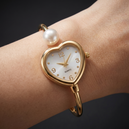 Women's elegant gold bracelet watch with modern pearl accents and delicate heart charm. Quartz movement.