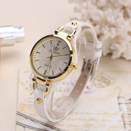 Women's gold quartz watch on a wrist, featuring a chic vegan leather strap, perfect fashion accessory.