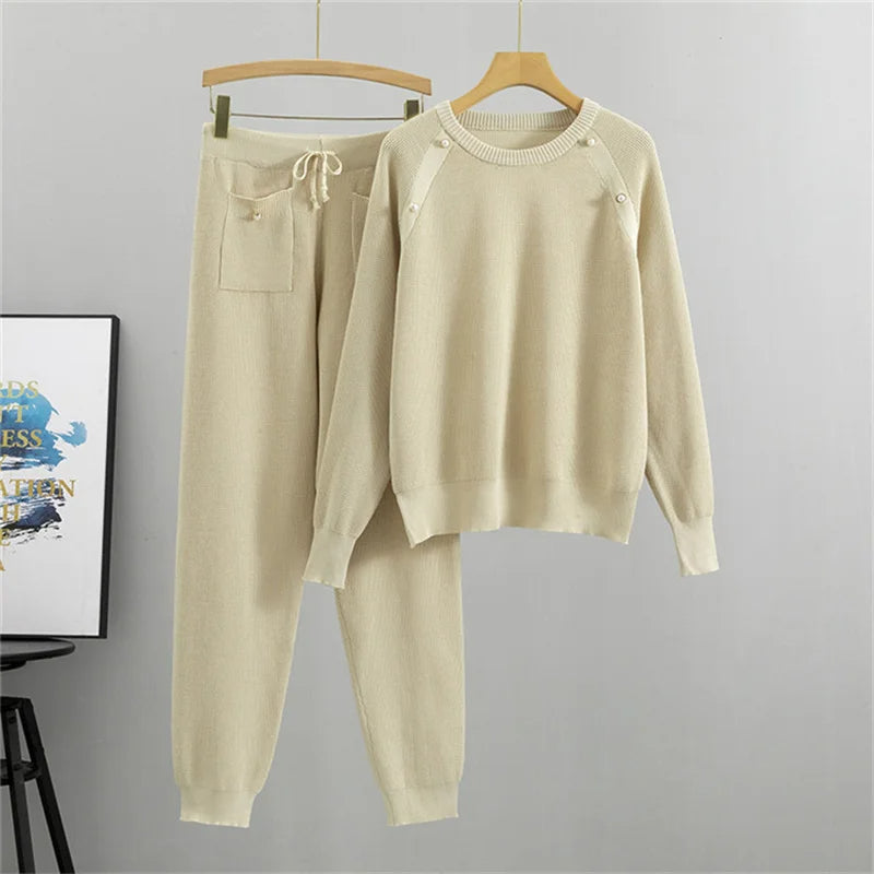 Relaxed fit women's knit lounge set with delicate pearl details. Soft two-piece sweater & jogger, ideal for elegant home attire.