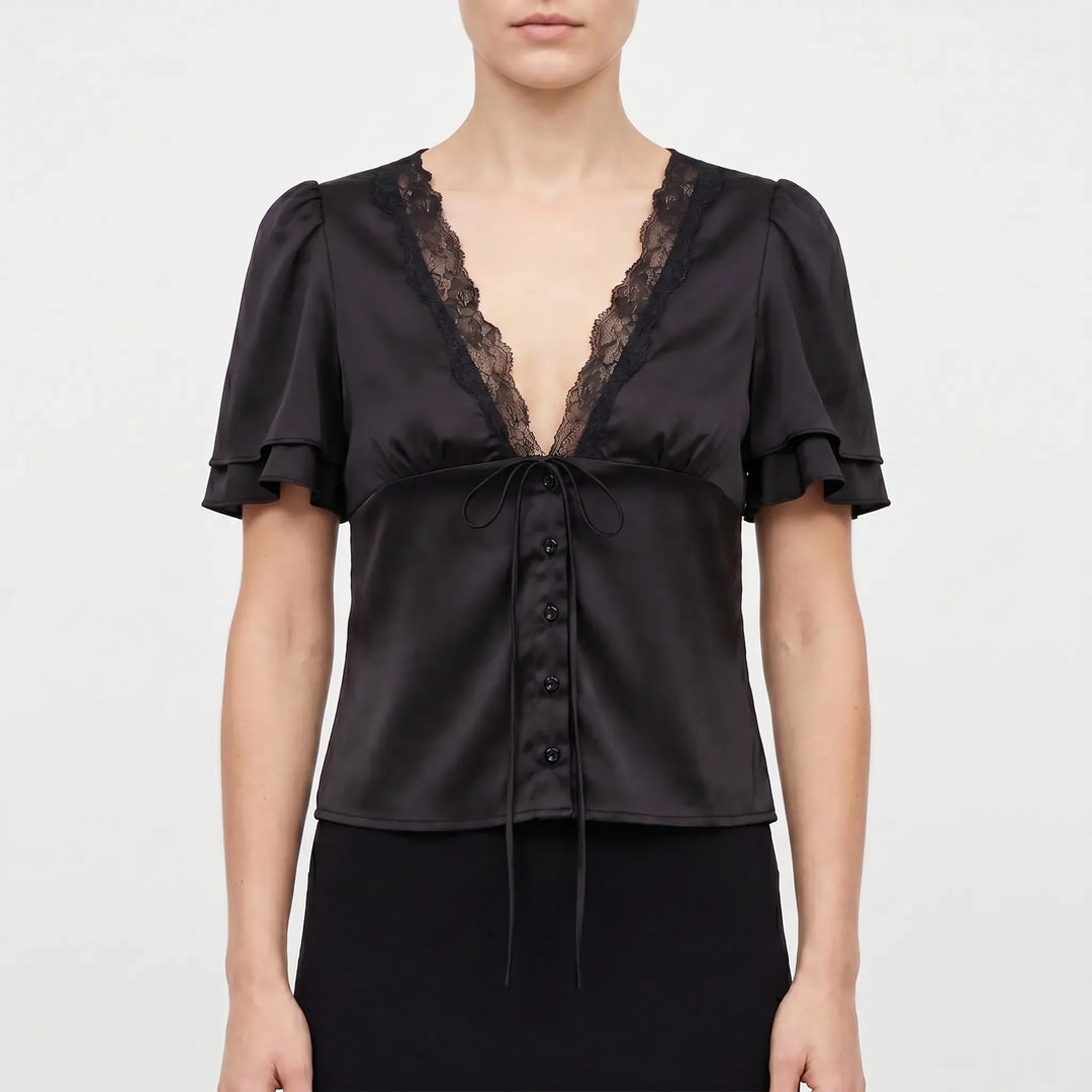 Solid color women's blouse with delicate lace trim, short flutter sleeves, and V-neck, offering versatile summer style.