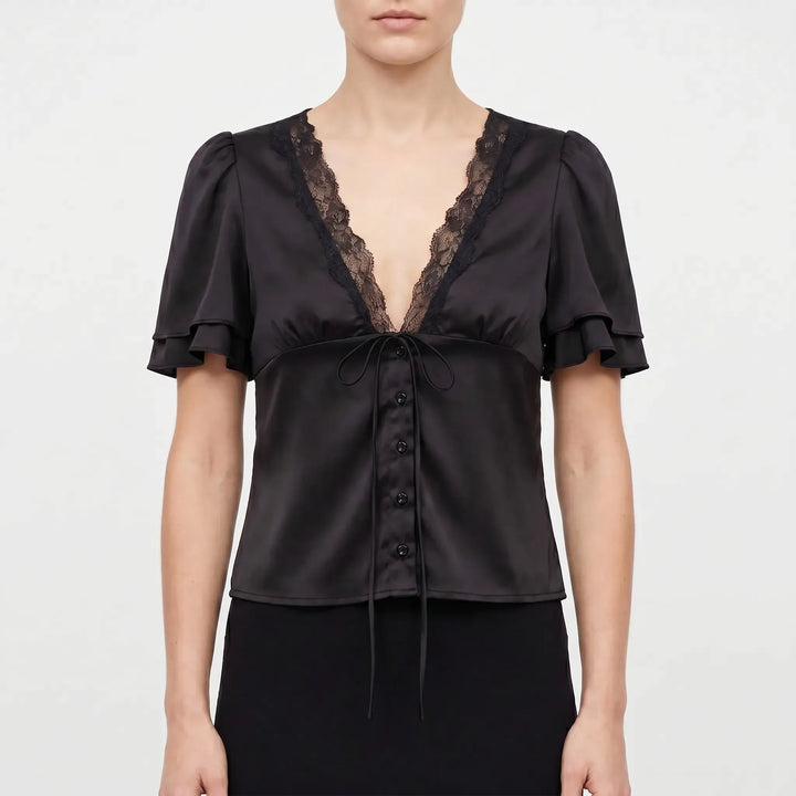 Solid color women's blouse with delicate lace trim, short flutter sleeves, and V-neck, offering versatile summer style.
