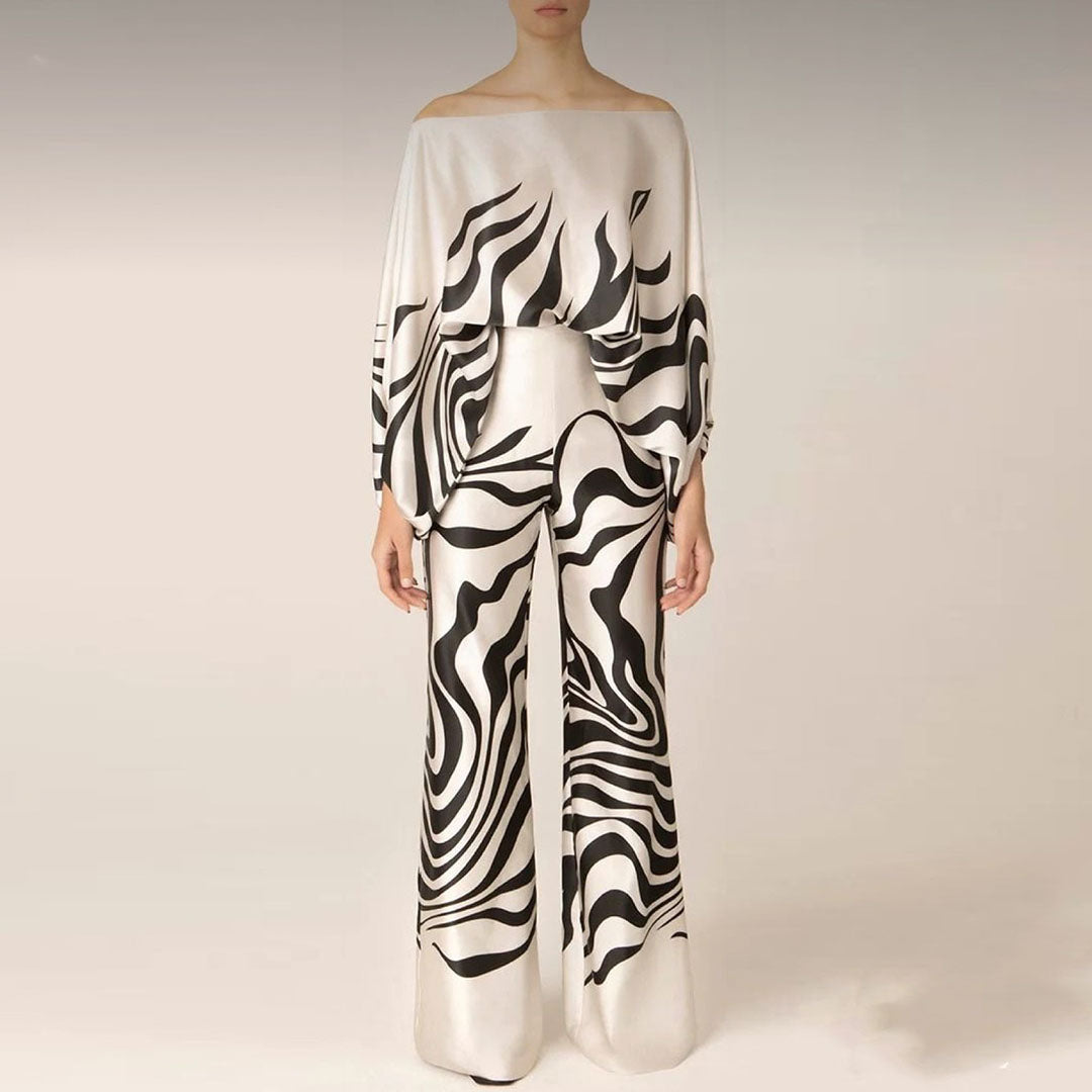 Full length view of women's one-shoulder abstract print two-piece pants set, ideal for elegant resort wear.
