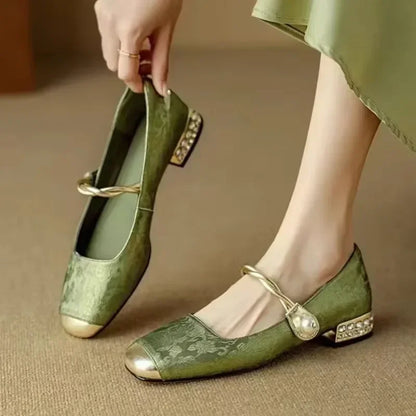 Stylish women's slip-on pearl flats with a comfortable low heel, ideal for evening or casual wear.