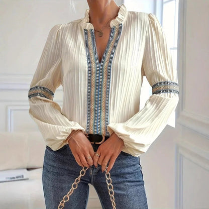 Stylish women's long sleeve blouse featuring elegant pleats and intricate lace detailing on a sophisticated top.