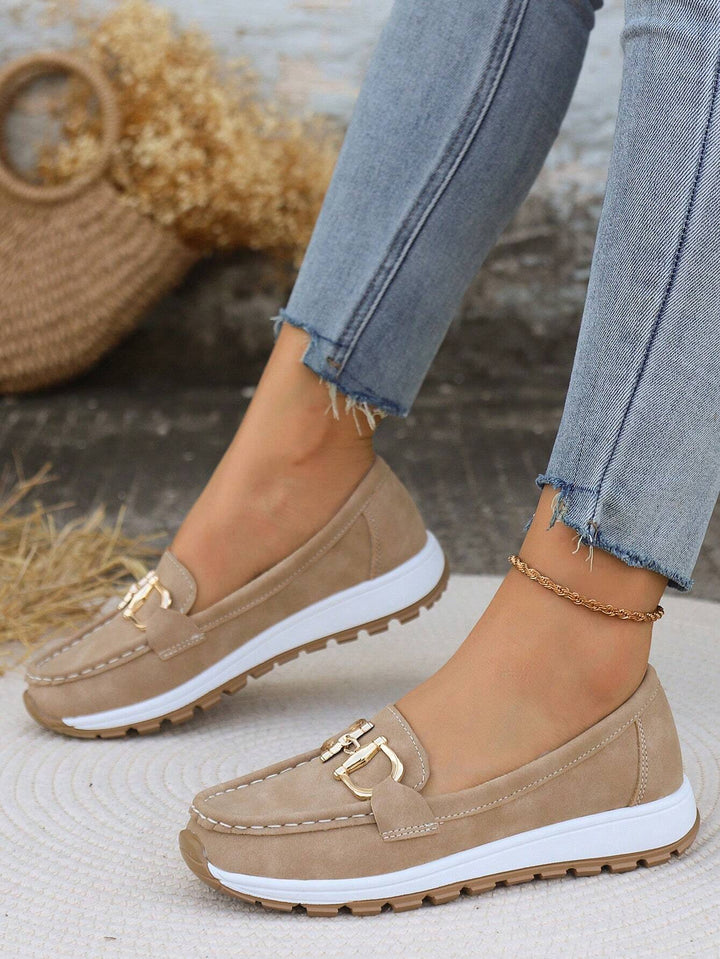 Soft women's elegant slip-on loafers with a distinctive gold buckle, blending comfort and fashion.