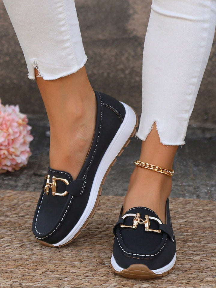 Side view of women's flat loafers, highlighting the elegant gold buckle and comfortable slip-on fit.