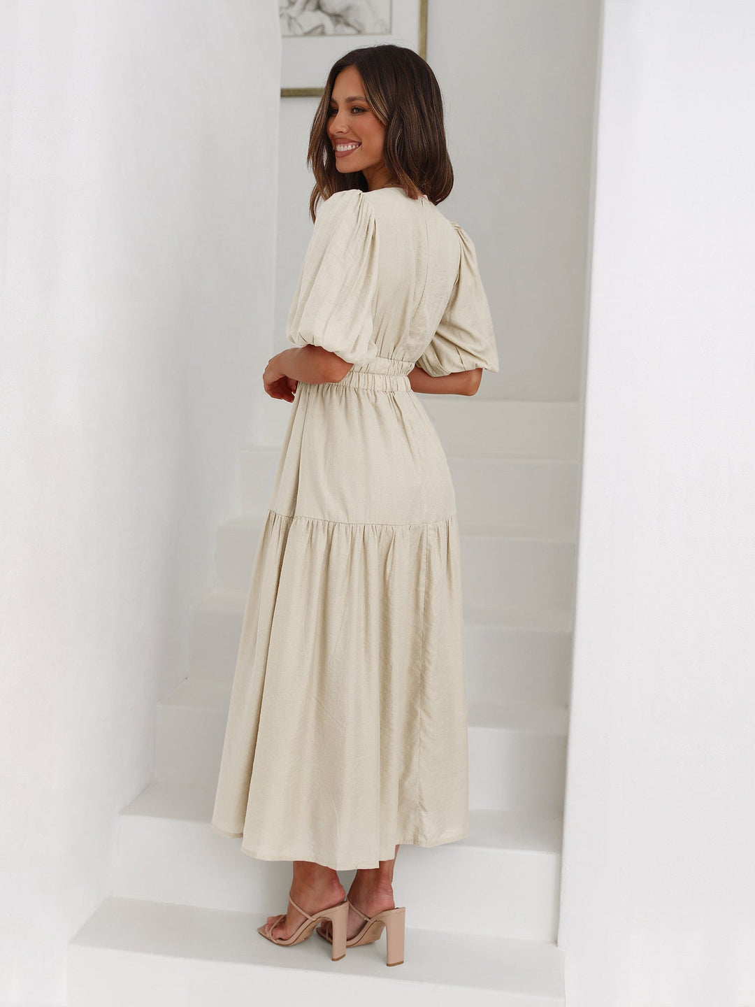 A-line V-neck midi dress with puff sleeves & smocked waist, creating an elegant silhouette for women.