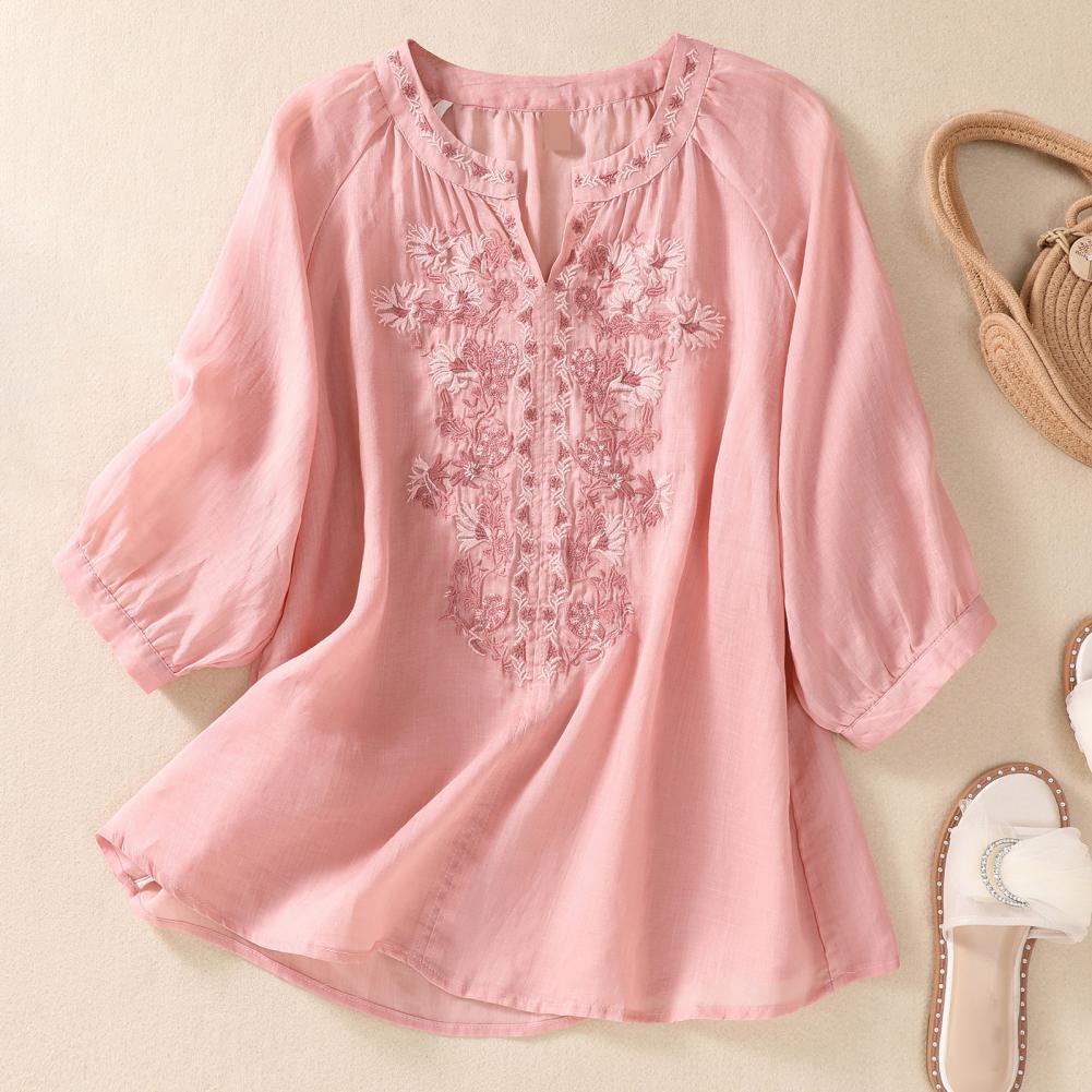 Elegant women's white blouse with detailed floral embroidery and gathered neckline, perfect for spring fashion.