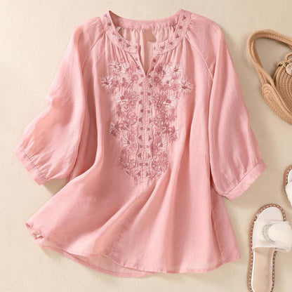 Elegant women's white blouse with detailed floral embroidery and gathered neckline, perfect for spring fashion.