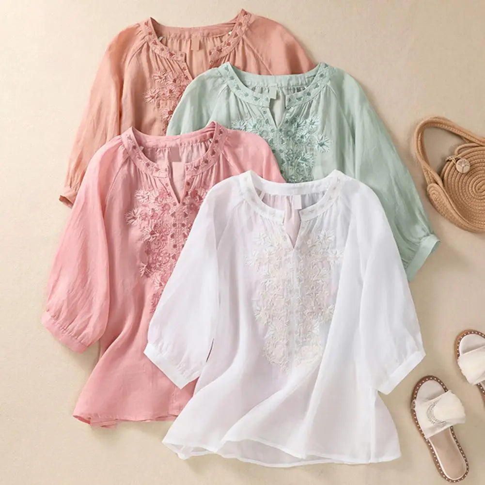 Casual white women's floral top featuring vibrant orange, green, pink embroidery. Comfortable for summer.