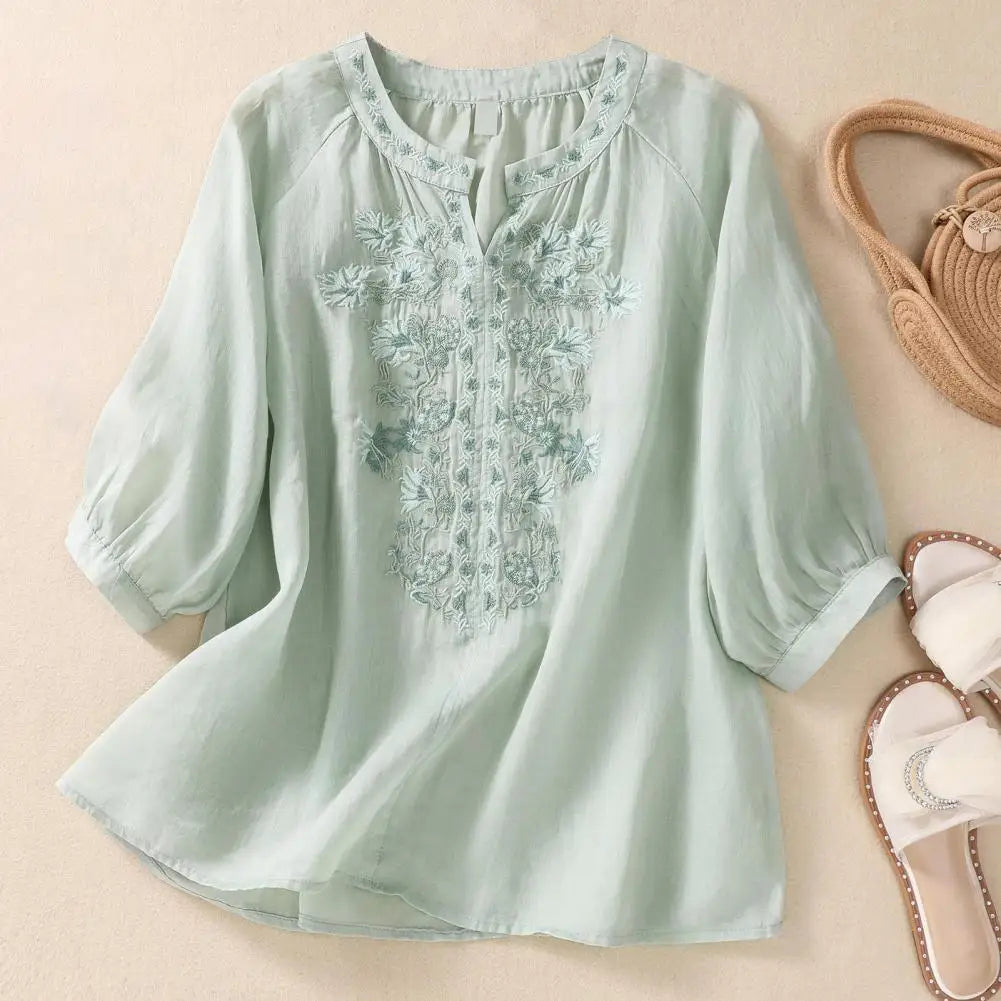 Women's comfortable white blouse featuring colorful floral embroidery, an elegant top for casual wear.