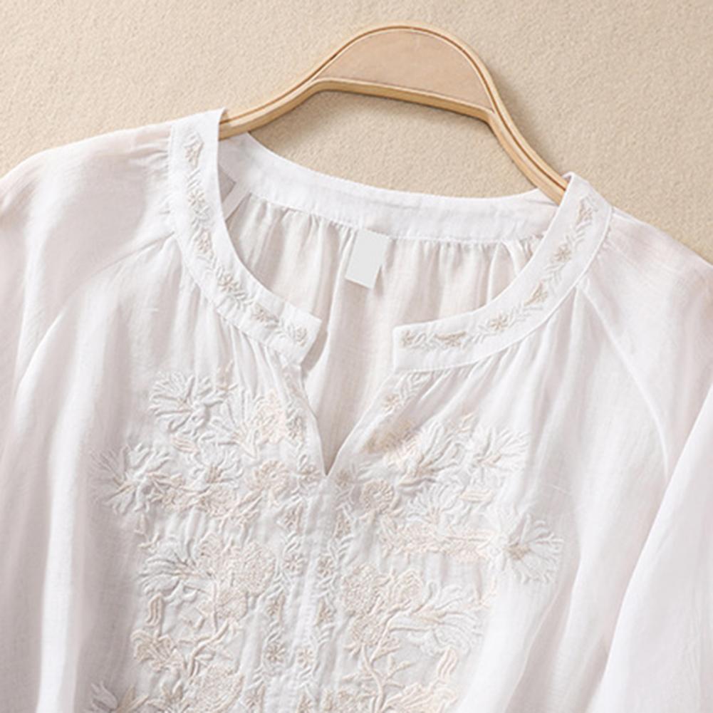 Lightweight women's elegant white floral blouse, embroidered with vibrant colors, ideal for summer comfort.