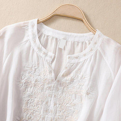 Lightweight women's elegant white floral blouse, embroidered with vibrant colors, ideal for summer comfort.