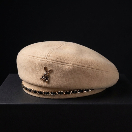 Women's elegant wool-blend cap with a striking golden bee emblem. Stylish fashion accessory for women.