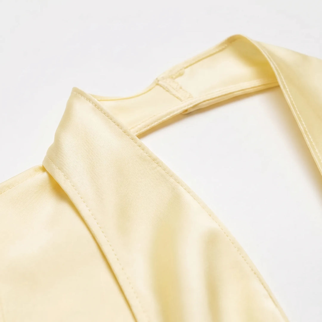 Stylish women's yellow draped halter blouse featuring a unique asymmetrical hem for a modern look.