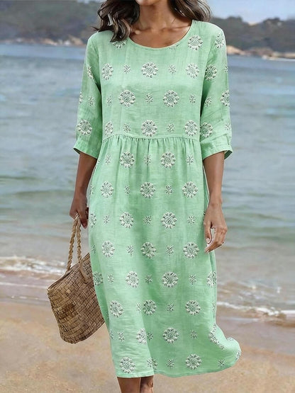 Beautiful women's floral embroidered midi dress. Three-quarter sleeves, round neck. Elegant summer or spring fashion.