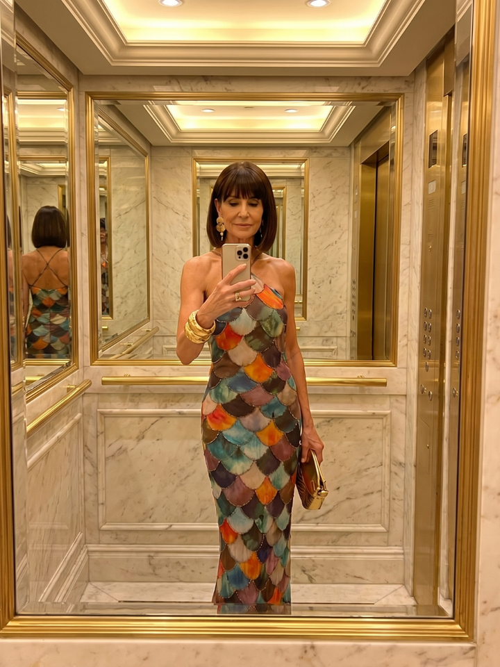 Full-length view of a women's fitted maxi dress with an eye-catching geometric scale print and halter neckline.