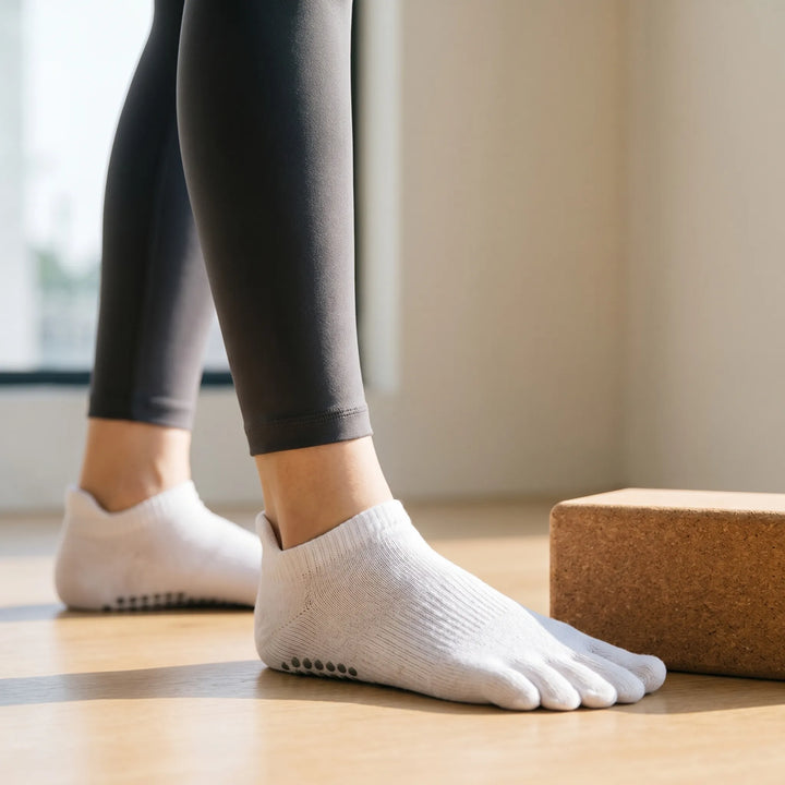 Women's five-toe grip socks for yoga & pilates, featuring non-slip soles for enhanced stability during studio fitness.