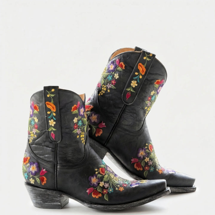 Close-up: Women's floral embroidered western ankle boots, showcasing intricate stitching & durable design.