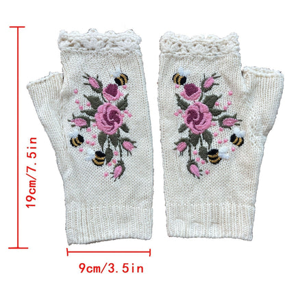 Hand-knitted women's fingerless gloves with beautiful floral embroidery. Cozy crochet winter fashion accessory.