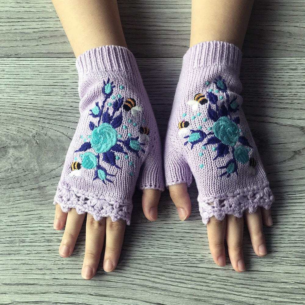 Comfortable women's fingerless knit gloves featuring vibrant floral embroidery. Perfect winter fashion accessory.