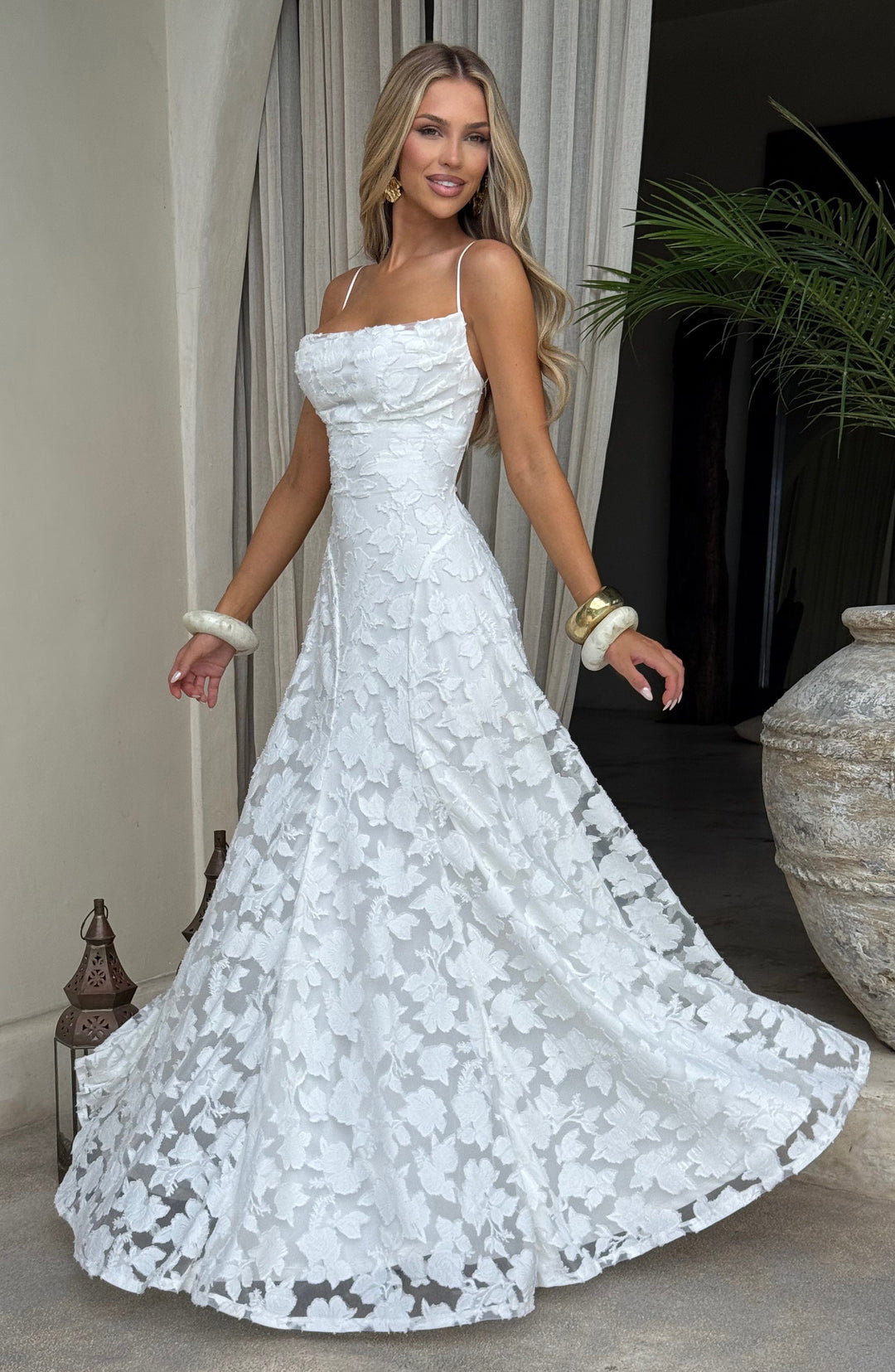 Rear view of women's floral maxi dress, highlighting the intricate lace-up back and long elegant skirt.