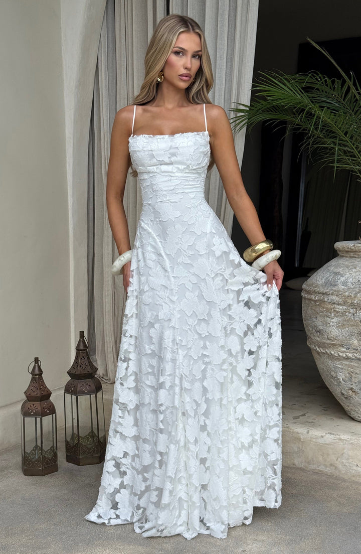 Model wearing a women's floral maxi dress, sleeveless with a waterfall neckline & stylish lace-up back.