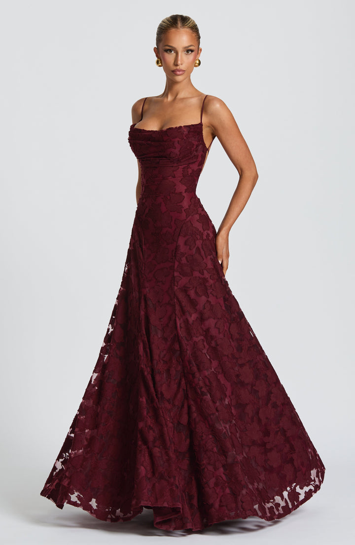 Women's floral maxi dress swaying gracefully, with a waterfall neckline & elegant long skirt.