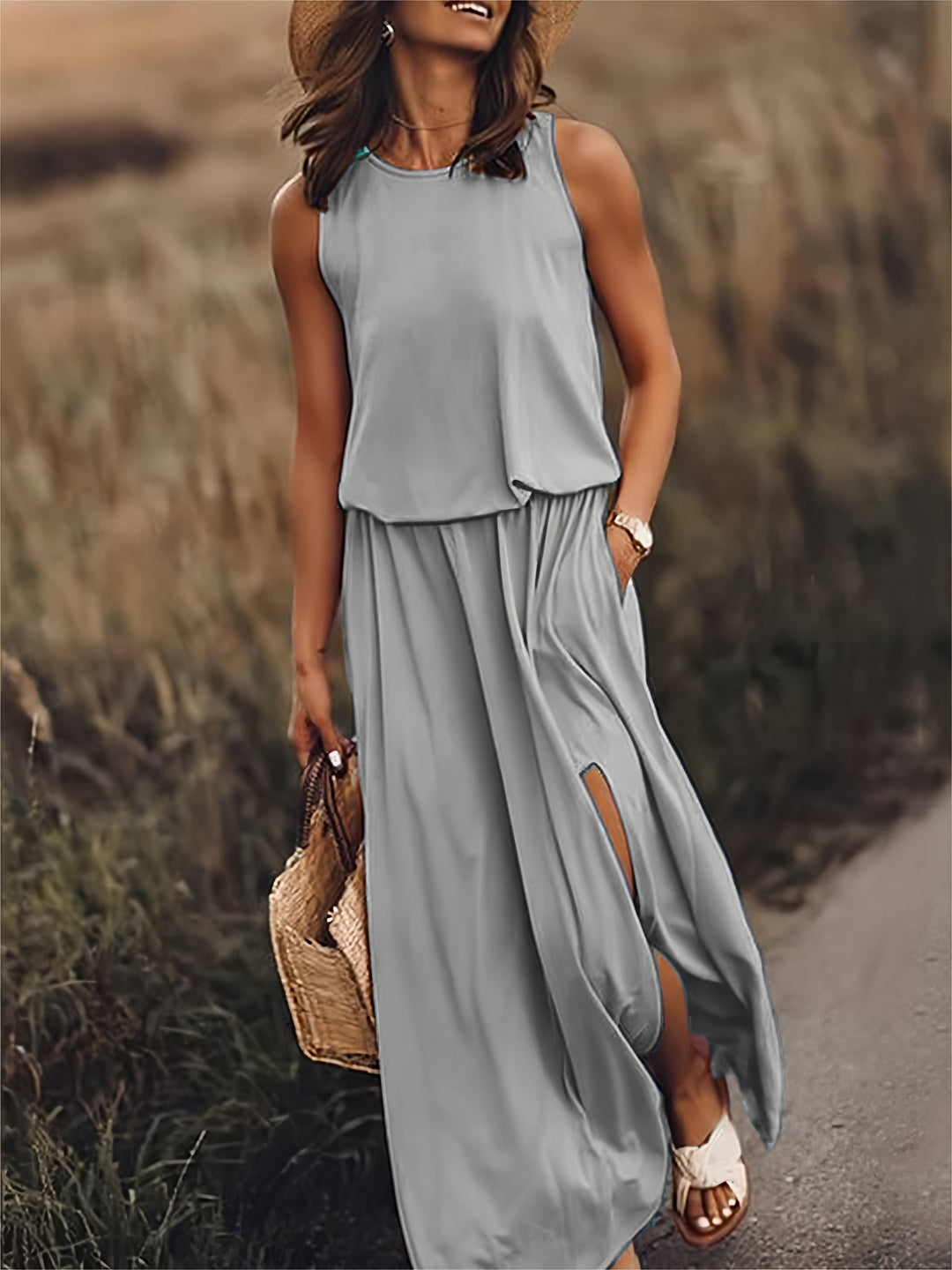 Women's sleeveless flowy maxi dress with practical side pockets, elastic waist, and graceful side slit.