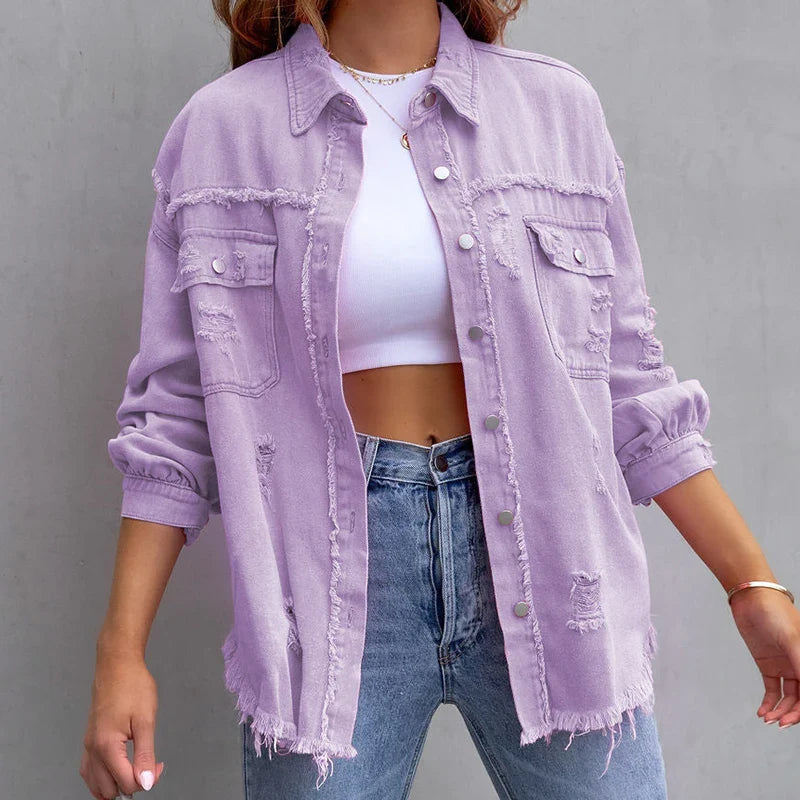 Blue denim women's jacket with edgy frayed seams and distressed texture, a trendy casual outerwear piece.