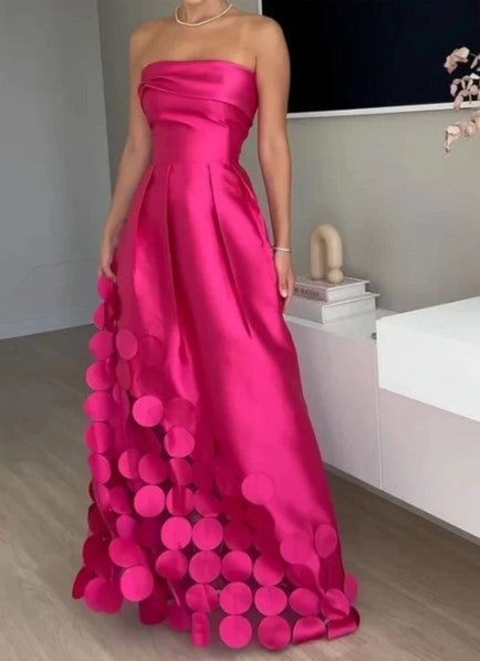 Women's fuchsia strapless maxi wedding guest dress with A-line silhouette & elegant petal hem for formal occasions.