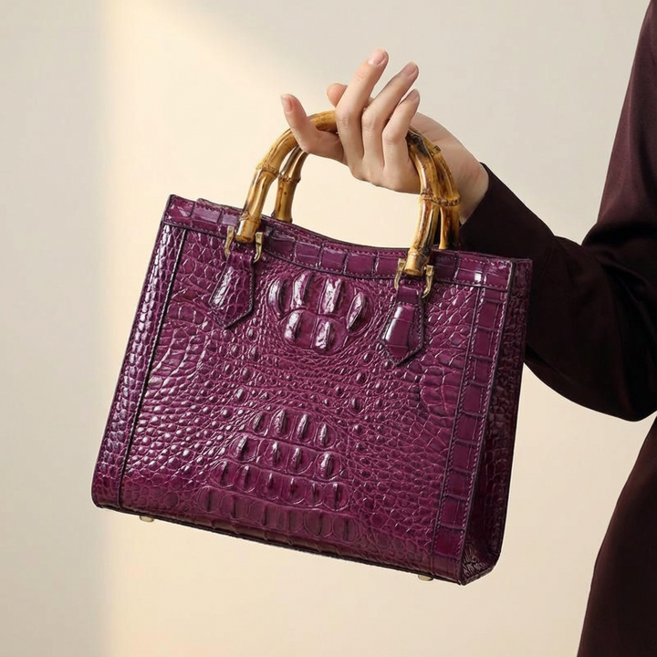 Luxury women's crocodile-pattern genuine leather handbag with distinctive bamboo handle. Fashion statement.
