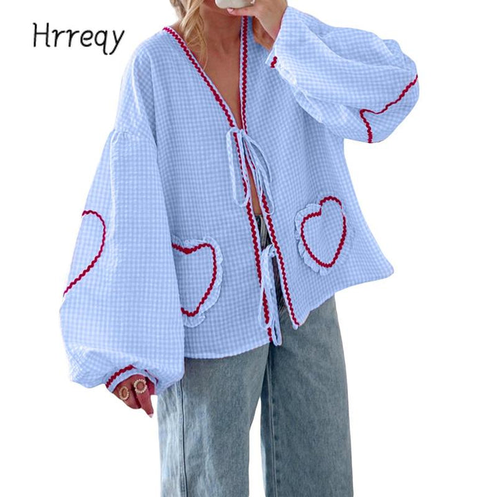 Women's gingham heart blouse with a stylish tie-front and voluminous sleeves, perfect for spring fashion.