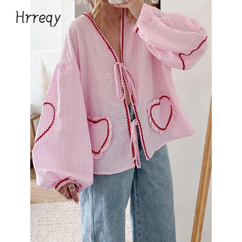 Spring fashion women's gingham blouse with heart applique, a chic tie-front, and voluminous sleeves for casual elegance.